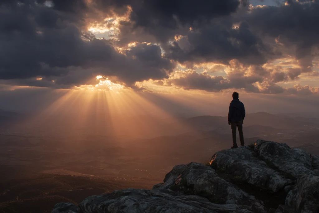 Homem no Topo da montanha contemplando a paisagem e sua evolução